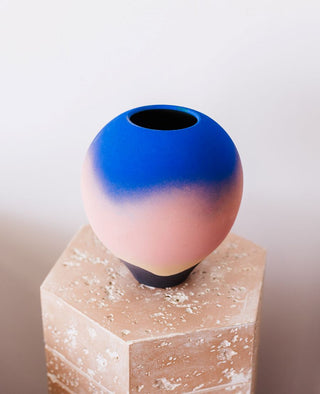 Studio Pottery Sunset Vase by Jan Twyerould placed on a faux stone pedestal, top view