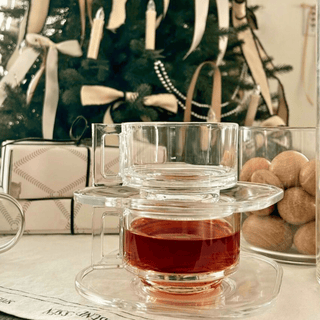 Stacked Joe Colombo Arno Teacups and Saucers with christmas tree and presents in the background 