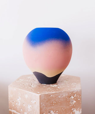 Studio Pottery Sunset Vase by Jan Twyerould placed on a faux stone pedestal